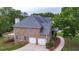 Brick home featuring an attached two-car garage and a spacious wooden deck at 60 Heritage Keep, Covington, GA 30016
