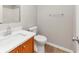 Clean bathroom with a white sink and wooden vanity, toilet, and towel rack at 1023 Saint Augustine Pkwy, Locust Grove, GA 30248