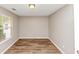 Empty bedroom with hardwood-style floors, one window and a flush ceiling light fixture at 1023 Saint Augustine Pkwy, Locust Grove, GA 30248