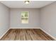 Neutral bedroom features light-colored walls and floors and a window with wooded outdoor views at 1023 Saint Augustine Pkwy, Locust Grove, GA 30248
