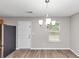 Dining area featuring a silver chandelier, hardwood floors, and a bright window with natural light at 1023 Saint Augustine Pkwy, Locust Grove, GA 30248