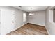 Dining room with a modern chandelier, hardwood floors, a white door, and abundant natural light at 1023 Saint Augustine Pkwy, Locust Grove, GA 30248