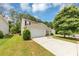 Traditional two-story home with a two car garage, driveway and front lawn with green grass and mature trees at 1023 Saint Augustine Pkwy, Locust Grove, GA 30248