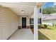 Inviting front porch with neutral siding and trim, a brick foundation, and a black front door at 1023 Saint Augustine Pkwy, Locust Grove, GA 30248