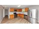 Well-lit kitchen features stainless steel appliances, wooden cabinets, and light wood flooring at 1023 Saint Augustine Pkwy, Locust Grove, GA 30248