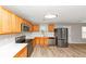 Well-lit kitchen with stainless steel appliances, wood cabinets, white countertops, and light wood flooring at 1023 Saint Augustine Pkwy, Locust Grove, GA 30248