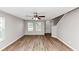 Bright living room with hardwood floors, a ceiling fan, and natural light from the large double windows at 1023 Saint Augustine Pkwy, Locust Grove, GA 30248