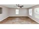 Spacious living room with hardwood floors, grey walls, a ceiling fan, and large windows that offer ample light at 1023 Saint Augustine Pkwy, Locust Grove, GA 30248