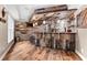 A custom bar with a stone countertop, ample seating, wooden accents, and modern lighting at 1985 Chapel Estates Ln, Dacula, GA 30019