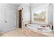 Bathroom featuring a large soaking tub, tiled shower, and natural lighting at 1985 Chapel Estates Ln, Dacula, GA 30019