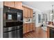 Modern kitchen with stainless steel refrigerator, wood cabinets, and granite countertops at 1985 Chapel Estates Ln, Dacula, GA 30019
