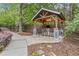 Inviting outdoor kitchen features a covered bar with chairs, TV and lights surrounded by lush landscaping at 1985 Chapel Estates Ln, Dacula, GA 30019