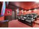Home theater room with red walls, tiered seating and a large flat screen television at 1985 Chapel Estates Ln, Dacula, GA 30019
