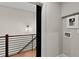 Hallway with wood floors and a modern metal railing leading to the utility room at 2329 Mason Dr # D24, Atlanta, GA 30316