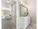 Bathroom vanity with white cabinets, gold hardware, and a framed mirror at 429 Tannenhill Pl, Sugar Hill, GA 30518