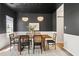 The dining room features a modern light fixture, dark walls, and a table with seating for six at 429 Tannenhill Pl, Sugar Hill, GA 30518