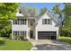 Charming two-story home featuring stone accents, a dark grey roof and a well-manicured lawn at 429 Tannenhill Pl, Sugar Hill, GA 30518