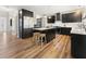 Modern kitchen features stainless steel appliances, black cabinets, and an island with bar seating at 429 Tannenhill Pl, Sugar Hill, GA 30518