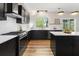 Bright kitchen with white countertops, black cabinets, modern appliances, and a view to the yard at 429 Tannenhill Pl, Sugar Hill, GA 30518