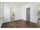 A bedroom featuring wood-look flooring, white walls, and a view into an ensuite bathroom at 102 Dahlia Nw Ave, Atlanta, GA 30314