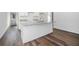 Kitchen island with a granite countertop, white cabinets, and wood-look floors at 102 Dahlia Nw Ave, Atlanta, GA 30314