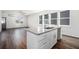 Open-concept kitchen featuring a granite island, white cabinets, and wood-look flooring at 102 Dahlia Nw Ave, Atlanta, GA 30314