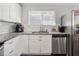 Bright kitchen features white cabinetry, stainless steel appliances, and granite countertops at 1599 Ezra Church Nw Dr, Atlanta, GA 30314