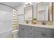 Bathroom with dual sinks, granite counters, and modern fixtures with a bathtub shower at 1908 Weston Ln, Tucker, GA 30084