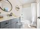 Updated bathroom with granite counters, gray cabinets, brushed bronze fixtures, and shower with white tile at 1908 Weston Ln, Tucker, GA 30084