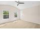Bright bedroom with neutral walls and carpet, two windows and ceiling fan at 1908 Weston Ln, Tucker, GA 30084