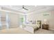 Bright main bedroom features a tray ceiling, ceiling fan, and multiple windows at 1908 Weston Ln, Tucker, GA 30084