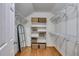 Organized walk-in closet with white shelving units, metal racks and a wooden mirror for efficient storage solutions at 3573 Turtle Cove Se Ct, Marietta, GA 30067