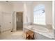 Luxurious bathroom featuring marble countertop, soaking tub with elegant fixtures, and a glass-enclosed shower at 492 Conway Manor Nw Dr, Atlanta, GA 30327