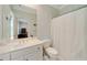 Bright bathroom featuring white cabinets, ample counter space, and a shower behind a white curtain at 492 Conway Manor Nw Dr, Atlanta, GA 30327