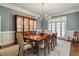 Formal dining room featuring elegant wood table, china cabinet, and French doors for natural light at 492 Conway Manor Nw Dr, Atlanta, GA 30327