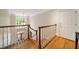 Upstairs hallway with hardwood floors, white railings, and a bright window, leading to a doorway at 492 Conway Manor Nw Dr, Atlanta, GA 30327