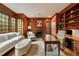 Elegant home office with wood paneling, built-in bookshelves, and a cozy seating area at 492 Conway Manor Nw Dr, Atlanta, GA 30327