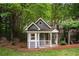 Charming playhouse nestled among mature trees, adjacent to a wooden swing at 492 Conway Manor Nw Dr, Atlanta, GA 30327