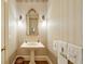 Stylish powder room featuring elegant wallpaper, pedestal sink, decorative mirror, and sconce lighting at 492 Conway Manor Nw Dr, Atlanta, GA 30327