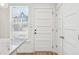 Hallway area showcasing a white front door with many panels and a glimpse of the outside at 1095 Tucker Ave # 207, Atlanta, GA 30310