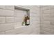 Modern tiled shower niche with accent tile and stylish soap bottle at 1095 Tucker Ave # 207, Atlanta, GA 30310