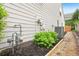 The property's exterior features a tidy side yard with gravel path, utility fixtures, and lush vegetation at 1620 Diplomat Dr, Cumming, GA 30041