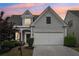 Charming home featuring a well-manicured lawn, a two-car garage, and a welcoming front entrance at 1620 Diplomat Dr, Cumming, GA 30041