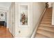 Hallway view with staircase, decorative flower display, and entrance to living room at 1620 Diplomat Dr, Cumming, GA 30041
