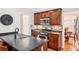 A well-lit kitchen with dark cabinets, stainless steel appliances, mosaic tile backsplash and an island with seating at 1620 Diplomat Dr, Cumming, GA 30041