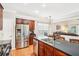Bright kitchen featuring dark wood cabinets, stainless steel appliances and a large island with sink and counter seating at 1620 Diplomat Dr, Cumming, GA 30041