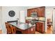 A well-lit kitchen with dark cabinets, stainless steel appliances, mosaic tile backsplash and an island with seating at 1620 Diplomat Dr, Cumming, GA 30041