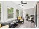 Cozy sunroom featuring large windows, wicker furniture, and a ceiling fan at 1620 Diplomat Dr, Cumming, GA 30041
