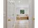 Hallway view of the bathroom with a tiled tub at 2305 Lochinver Sw Ln, Conyers, GA 30094