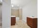 Simple bathroom featuring tile floors, a shower/tub, and wood vanities with white sinks at 2305 Lochinver Sw Ln, Conyers, GA 30094